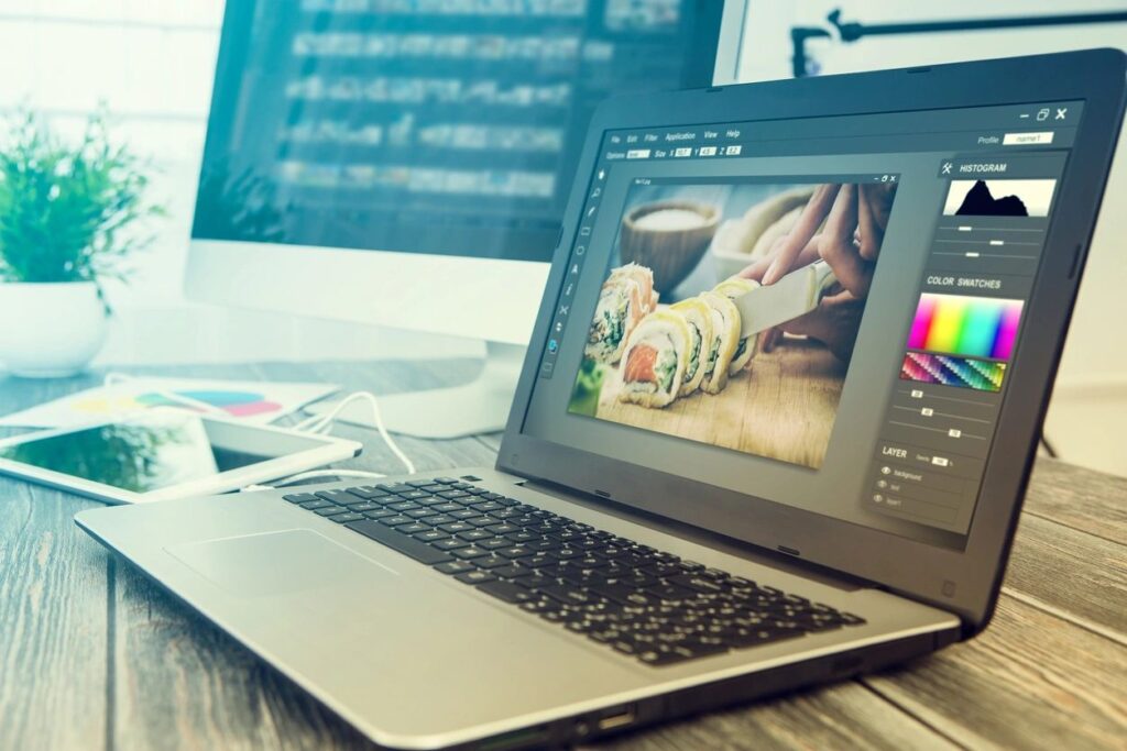 Laptop on a desk displaying image editing software